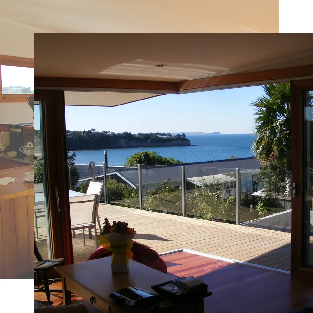 Living area opening onto a deck with a sea view, in a home built by Ecoconstruct