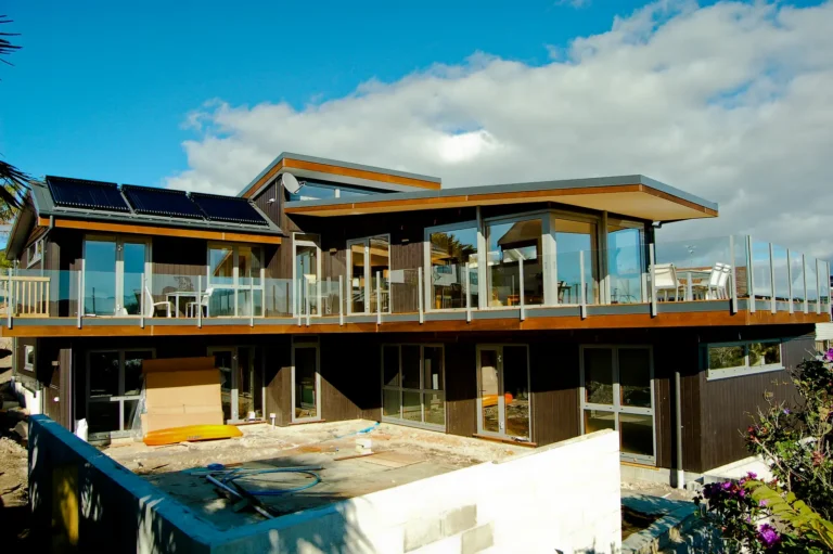 Timber clad home with solar panels on the roof and decks on two levels
